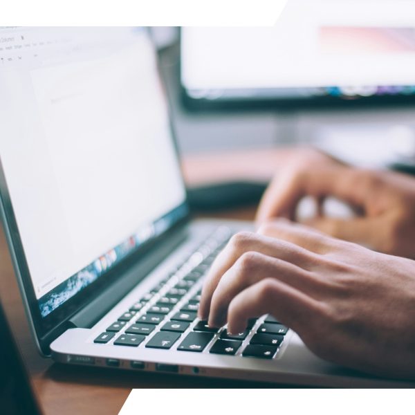 Hands typing on a laptop keyboard